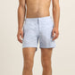 A man models Orlebar Brown Bulldog Swim Shorts in Surfside Blue, standing bare-chested with his hands by his sides against a plain light background.