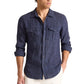 Man wearing the Orlebar Brown Colburn Lino Shirt, a tailored dark blue Italian linen button-up with front pockets, paired with white pants and standing against a plain white background.
