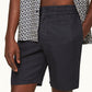 A person wears Orlebar Brown’s Cornell Linen Short—Italian-woven with an elasticated waistband—paired with a patterned shirt. The image is cropped to focus on the torso and upper legs, one hand relaxed at their side.