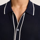 Close-up of a person wearing the Orlebar Brown Roddy Button Through Knitted Shirt in navy with textured waffle mesh and white piping—ideal for effortless summer tailoring.