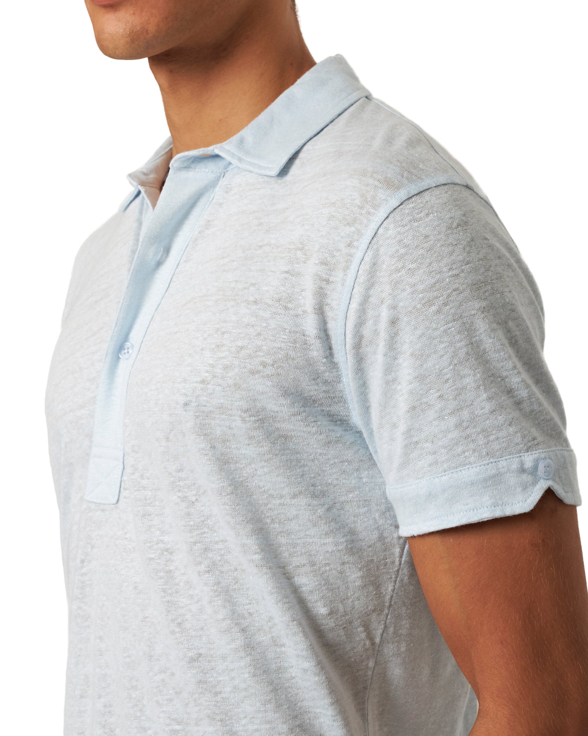A person in the Orlebar Brown Sebastian Linen Polo in light blue, shown from shoulders to mid-torso and facing slightly left.