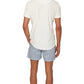 A man faces away, wearing the Orlebar Brown Terry Polo in white, crafted from breathable cotton towelling, paired with light blue striped shorts against a plain white background.