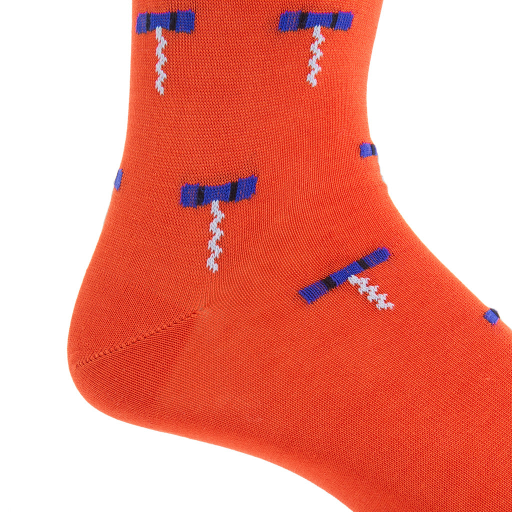 Close-up of a Dapper Classics Cork Screw Mid Calf Sock in Tigerlily Orange and Clematis Blue, showcasing its pattern of blue and white corkscrews. Made with breathable material for comfort, it features a seamless linked-toe design.