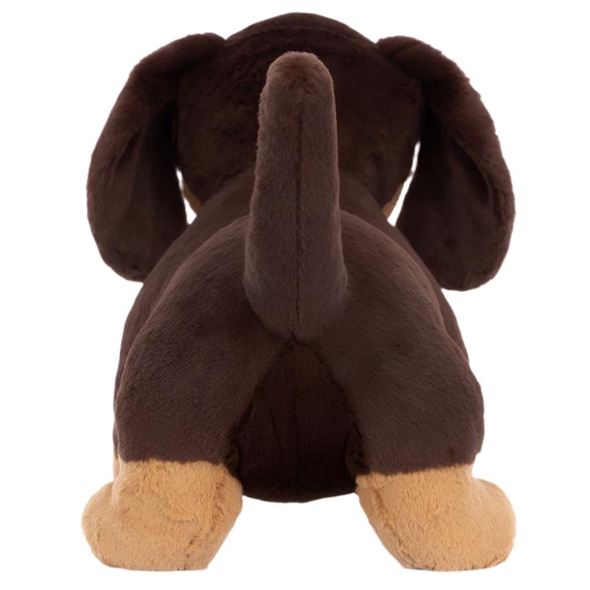 The Jellycat Otto Sausage Dog, Big by Jellycat is a plush toy with dark chocolate fur, floppy ears, and light brown legs and paws. Viewed from behind, this playful little pal is sure to bring joy to anyone who sees it.