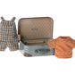 The Maileg Overalls & Shirt in Suitcase for Big Brother Mouse by Maileg features a small metal suitcase adorned with polka dots and a handle, containing a stylish clothes set: blue and white checkered overalls paired with an orange striped shirt.