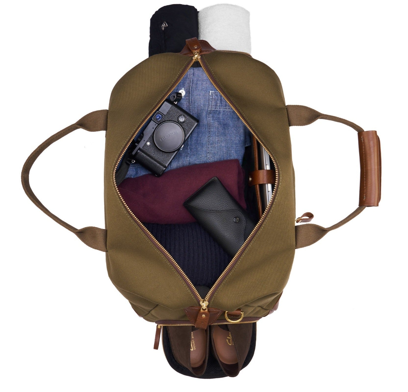 Bennett Winch Canvas Weekender bag crafted from waterproof canvas, containing neatly organized clothing, a camera, a sunglasses case, and sandals.