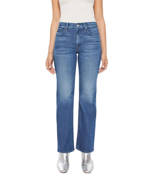 A person wears Mother’s Lil Kick It straight-leg blue jeans, a white sleeveless top, and silver shoes, standing against a plain background.