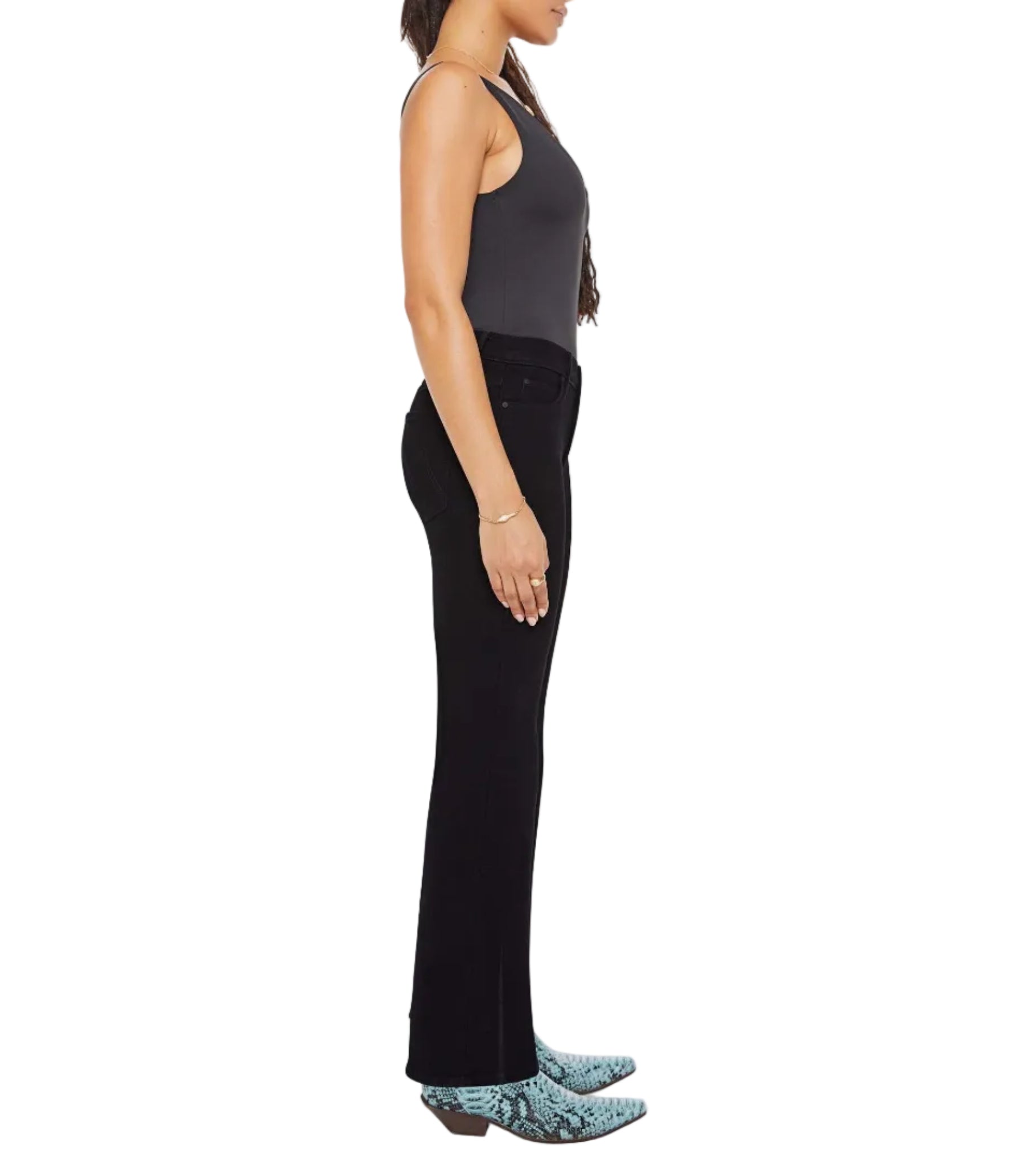 A woman stands in profile against a white background, wearing Mother Lil Kick It black sleeveless top and pants, paired with blue snake-print cowboy boots.