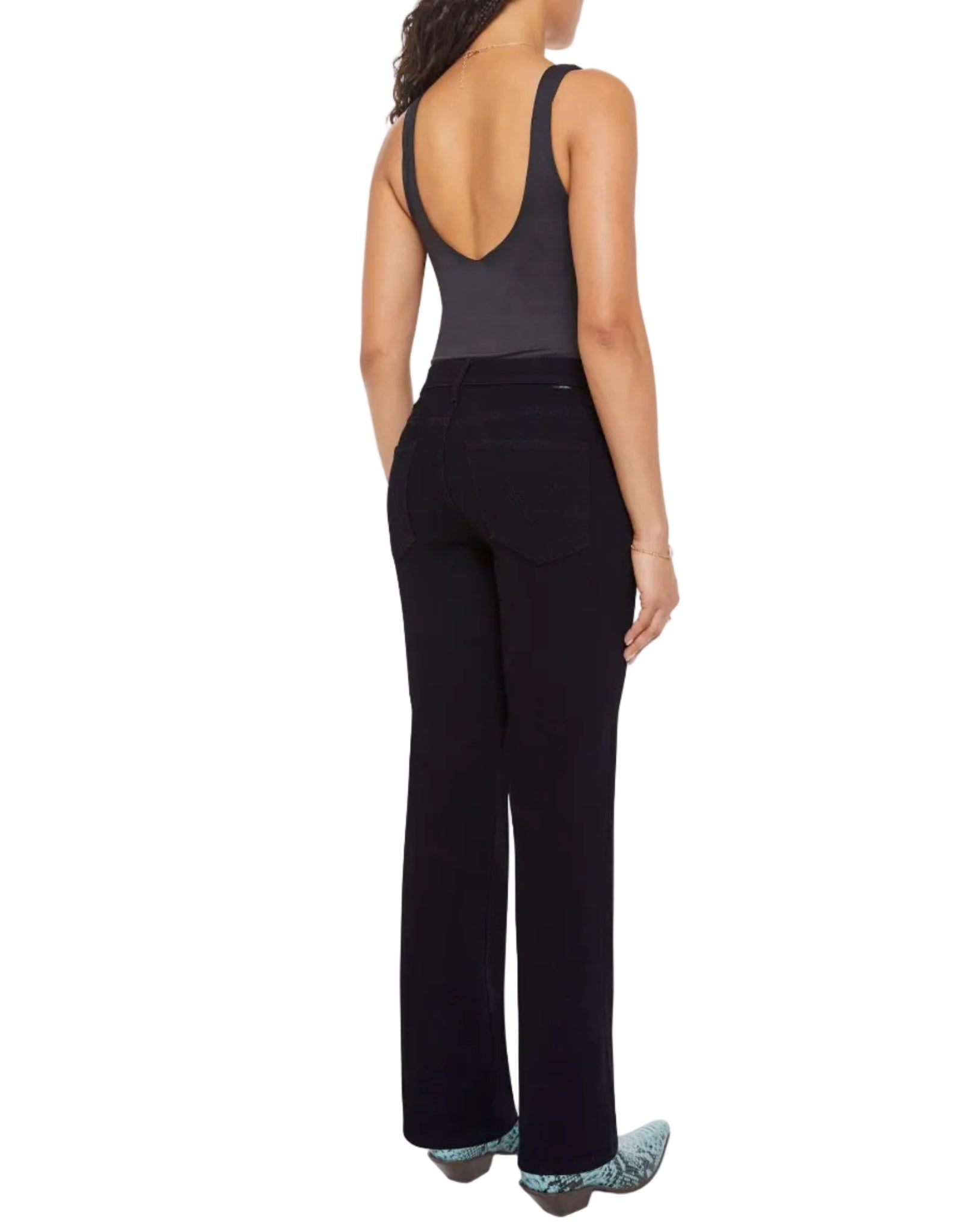 A person stands facing away, wearing the Mother Lil Kick It sleeveless black top with a low back and matching black pants, paired with patterned shoes against a white background.