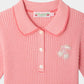 Bonpoint’s Girls’ Marlie Dress features pink and white stripes, a collared neckline with buttons, and an embroidered cherry patch on the chest, all crafted from soft organic cotton for all-day comfort.