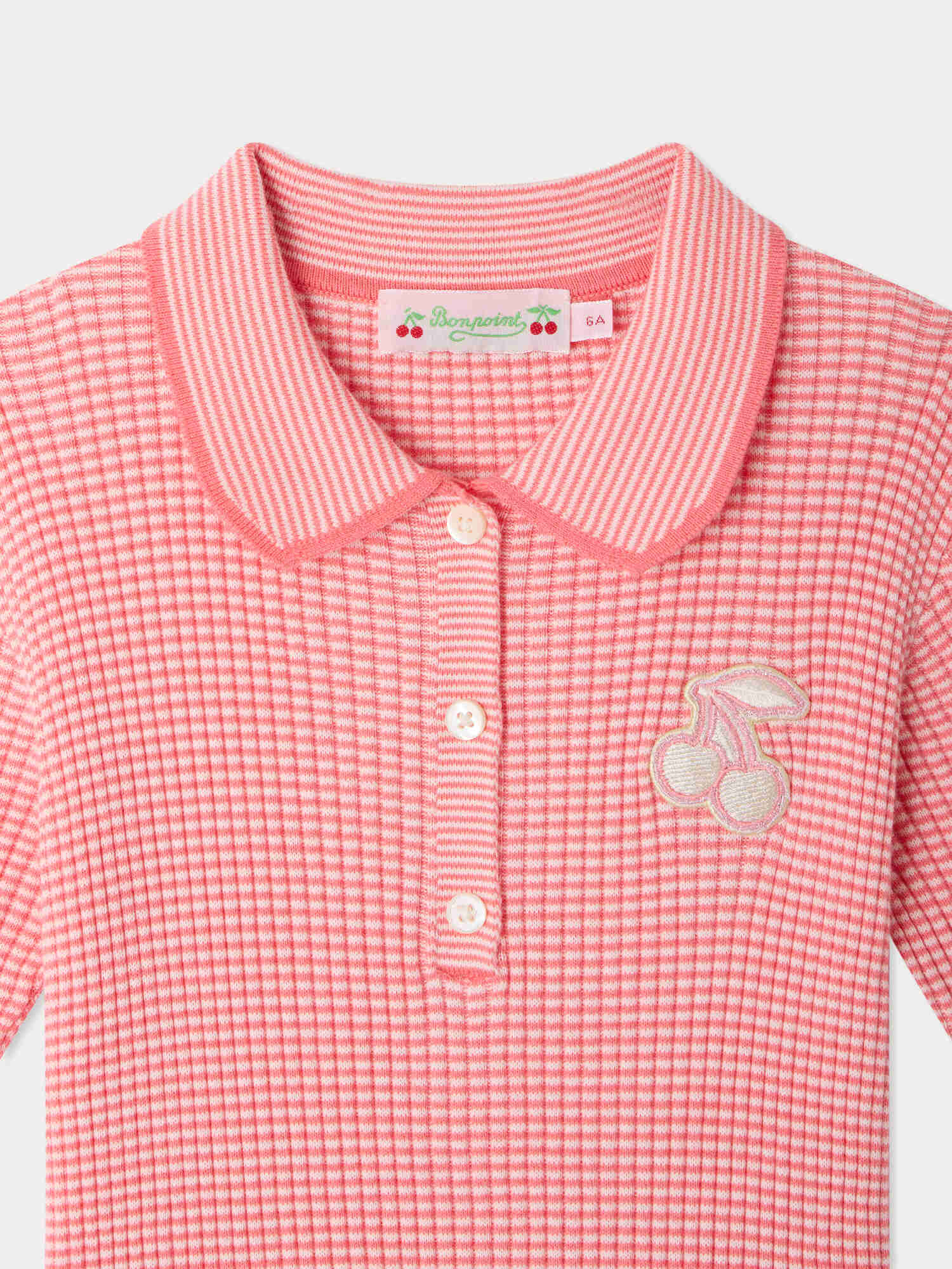 Bonpoint’s Girls’ Marlie Dress features pink and white stripes, a collared neckline with buttons, and an embroidered cherry patch on the chest, all crafted from soft organic cotton for all-day comfort.