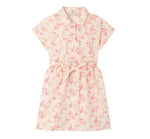 The Girls’ Gisele Dress by Bonpoint is a short-sleeved, collared, button-down shirt dress crafted from organic cotton with a pink and yellow floral print and a matching waist tie, shown against a white background.