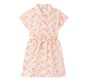 The Girls’ Gisele Dress by Bonpoint is a short-sleeved, collared, button-down shirt dress crafted from organic cotton with a pink and yellow floral print and a matching waist tie, shown against a white background.