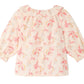 Introducing the Baby Girls’ Dolci Blouse by Bonpoint—a light pink children’s blouse featuring a ruffled collar, button-front closure, and a playful print of pink palm trees with yellow accents and the number “1975” scattered throughout. Crafted from soft organic cotton for all-day comfort, this charming floral print baby blouse is perfect for any occasion.