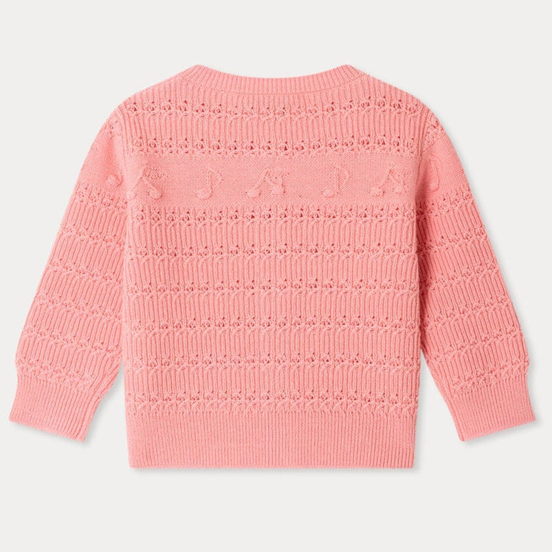 Bonpoint Baby Girls’ Mahana Cardigan in pink, featuring a decorative knit pattern and long sleeves, is displayed flat from the back. This design showcases subtle details across the upper section.