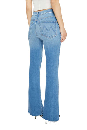 A person is wearing the Mother Denim Petites Lil High Waisted Weekender Fray jeans in light blue, featuring back pocket stitching shaped like the letter “M,” paired with a white top.