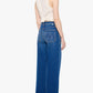 A woman stands facing away, wearing the Mother Petites Lil Patch Maven Sneak high-rise wide leg jeans crafted from recycled stretch denim with back pockets and a white sleeveless top tied at the back.