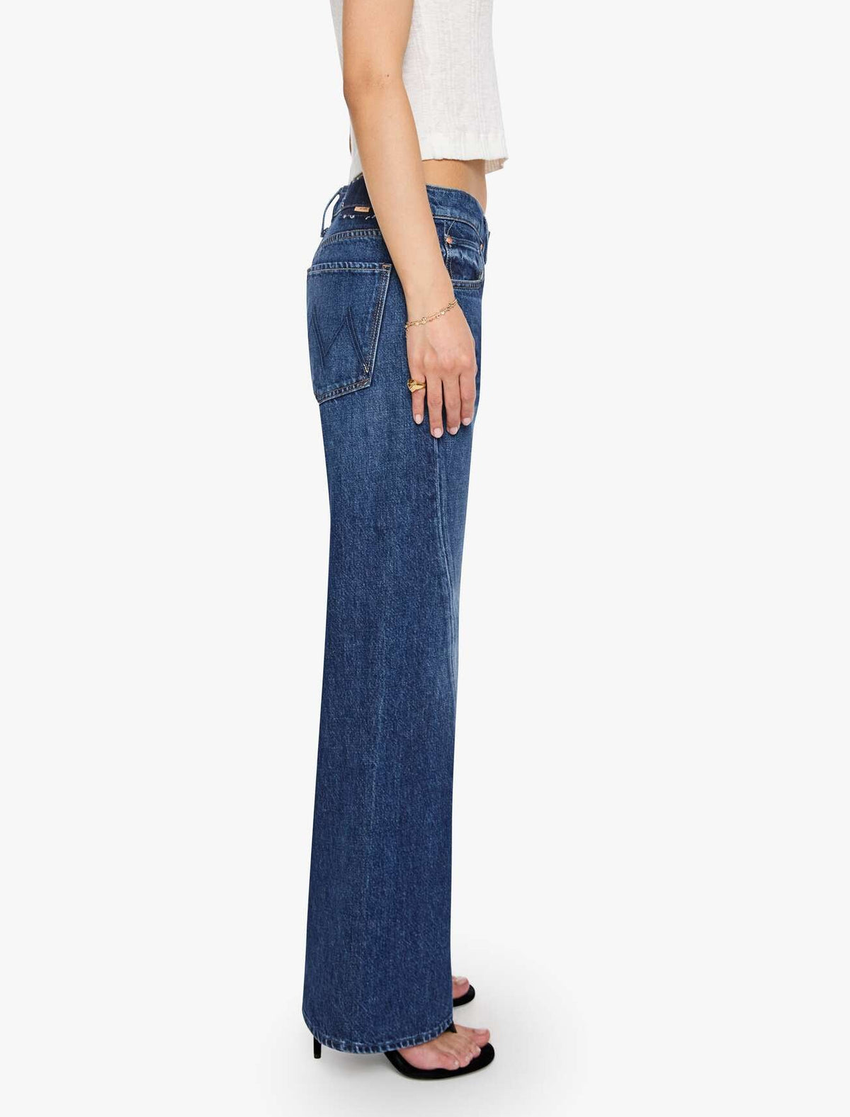Profile view of a person wearing high-waisted, full-length Mother Petites Lil Bookie Twist Skimp denim jeans.