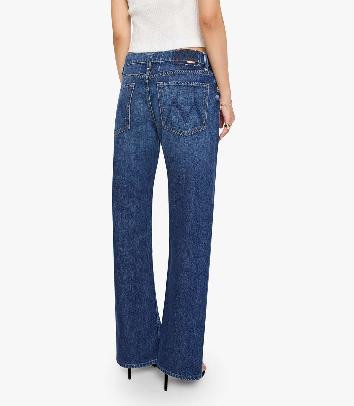 Back view of Mother Petites Lil Bookie Twist Skimp medium-wash blue denim jeans in a straight-leg fit with a stitched M design on the back pockets.