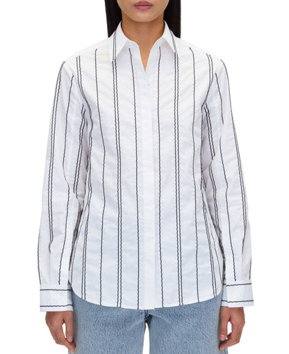 A person is shown from the waist up wearing a 3.1 Phillip Lim Poplin Shirt with Wave Embroidery and light blue jeans.