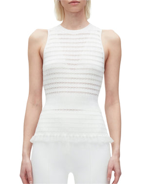 A woman wears the 3.1 Phillip Lim Shadow Stripe Tank—a sleeveless white textured top featuring a fitted waist and subtle frill detail at the peplum hem.