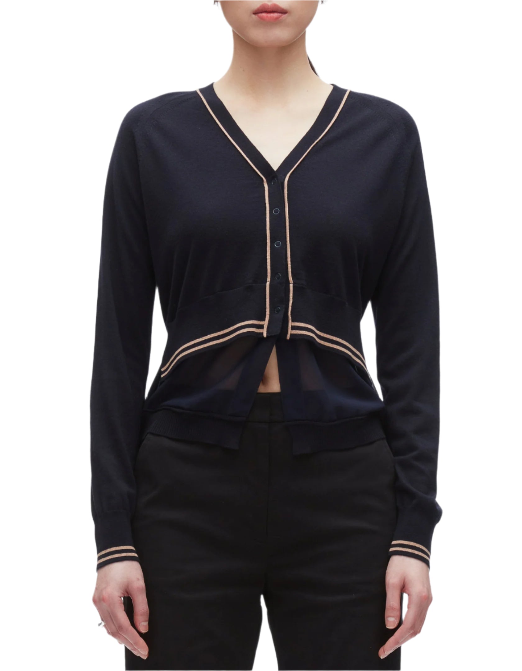 A woman wears the 3.1 Phillip Lim Chiffon Hem Boxy Cardigan, a varsity-inspired black V-neck with beige trim and long sleeves, featuring a sheer chiffon waist panel for a modern twist, paired with black pants.