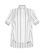 The Adam Lippes Trapeze Stripe Shirt is crafted from Italian cotton with ivory and black stripes, short sleeves, a pointed collar, and a slightly longer back hem.