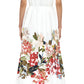 A person faces away, wearing the Adam Lippes Attacher Dress—an Italian cotton poplin collared style with floral print on the lower half, a waist sash, and strappy white heels.