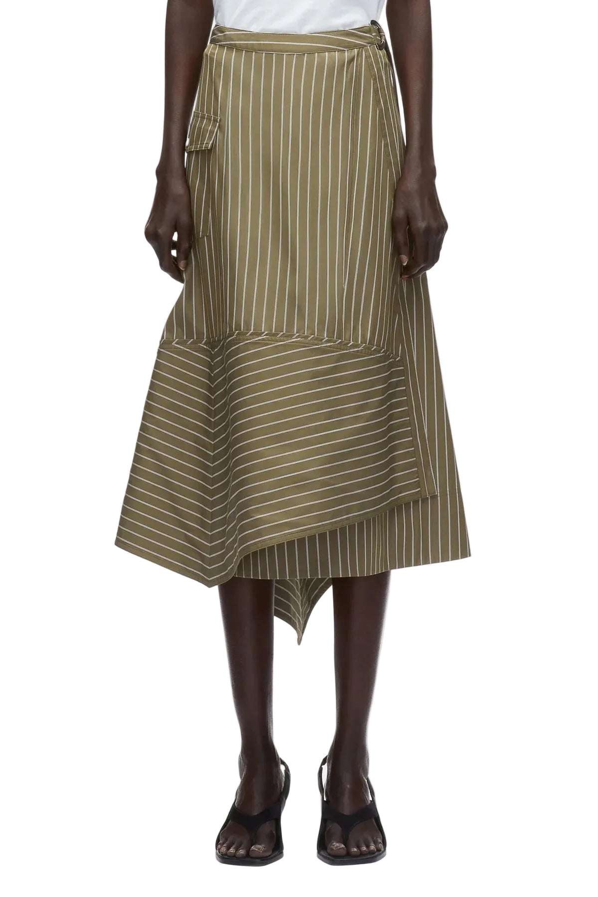 A person wears the 3.1 Phillip Lim Stripe Wrap Asymmetrical Hem Skirt—green and white pinstriped with a handkerchief hem and side pocket—paired with black sandals.