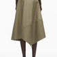A person in the 3.1 Phillip Lim Stripe Wrap Asymmetrical Hem Skirt, featuring khaki cotton with white vertical and diagonal pinstripes, styled with black heeled sandals.