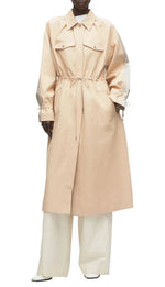 A person wears the 3.1 Phillip Lim Blouson Trench Coat in cotton-viscose twill, featuring front pockets and a cinched waist, styled over wide-leg white pants and white shoes, against a white background.