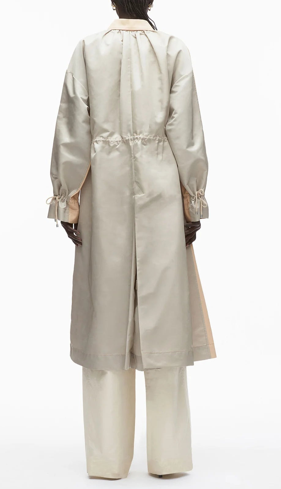 A person wearing the 3.1 Phillip Lim Blouson Trench Coat in light beige cotton-viscose twill with drawstrings at the waist and wrists, paired with matching wide-leg pants, is shown from the back against a white background.