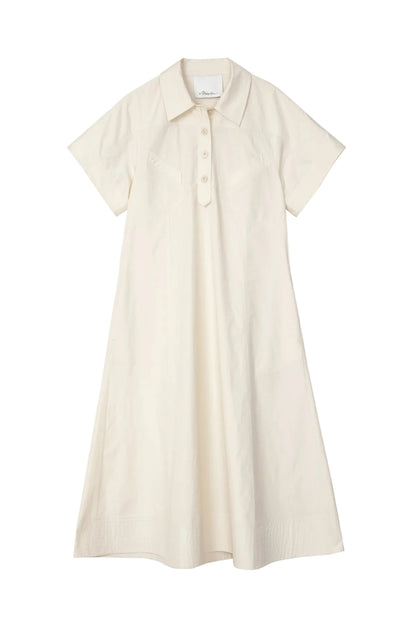 The Trapeze Midi Poplin Shirt Dress by 3.1 Phillip Lim is a cream short-sleeve, collared summer dress with chest buttons and an A-line silhouette, crafted in cotton poplin.