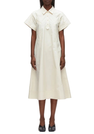 A person wearing the 3.1 Phillip Lim Trapeze Midi Poplin Shirt Dress in light beige with black flats stands against a plain background.