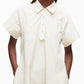 A person wears the 3.1 Phillip Lim Trapeze Midi Poplin Shirt Dress, a cream short-sleeve cotton dress with front buttons and pockets, standing against a plain background.