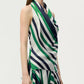 A woman wearing the Adam Lippes Cusette Printed Silk Twill Top—sleeveless, with green, navy, and white diagonal stripes—crafted from luxurious Italian silk twill and paired with a coordinating skirt.