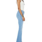 A woman in profile wears Mother’s PETITES Lil Weekender Fray petite jeans in light blue recycled stretch denim, a white tank top, and black strappy heels against a white background.