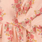 Close-up of the Konges Slojd Baby Girls' and Girls' Coco Blouse, a peach muslin top with red, yellow, and purple floral print, featuring gathered sleeve and waist details.