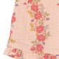 Close-up of Konges Slojd’s Baby Girls' and Girls' Coco Shorts in breathable pink muslin with a floral print, green leaves, and a ruffled hem—perfect for comfort and style.