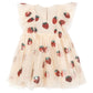 The Girls' Yvonne Frill Dress by Konges Slojd is a cream short-sleeved tulle dress with voluminous ruffled shoulders, a flared skirt, and red sequin strawberry appliqués.