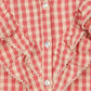 Close-up of the Girls' Kim Frill Shirt by Konges Slojd, featuring red and cream checkered seersucker fabric, ruffled frills, lace trim, and white buttons; label indicates size 3Y, made in China.