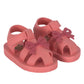 The Konges Slojd Kids' Sable Sandal is a pink toddler summer sandal with front bows, straps, and velcro fastening, shown on a white background.