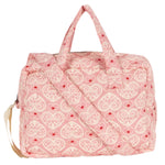 The Konges Slojd Lacy Pink Doll Bag features red hearts and floral patterns, soft shoulder straps, and a handy grab-and-go handle for easy carrying.