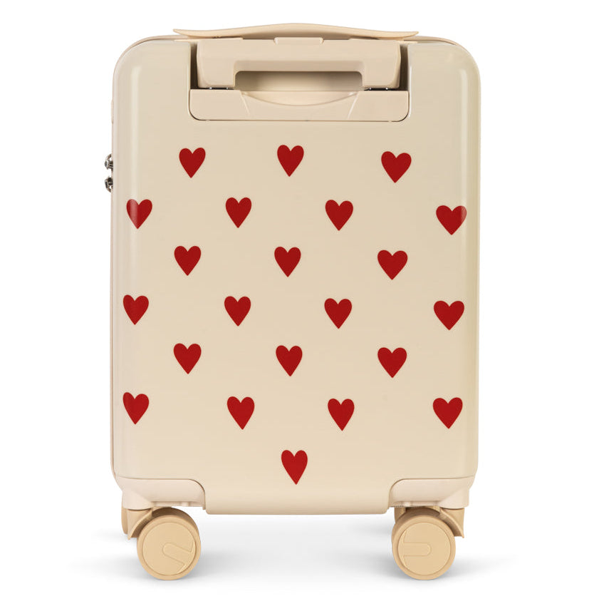 Cream-colored Konges Slojd Kids’ Travel Suitcase featuring a repeating pattern of small red hearts and a retractable handle.