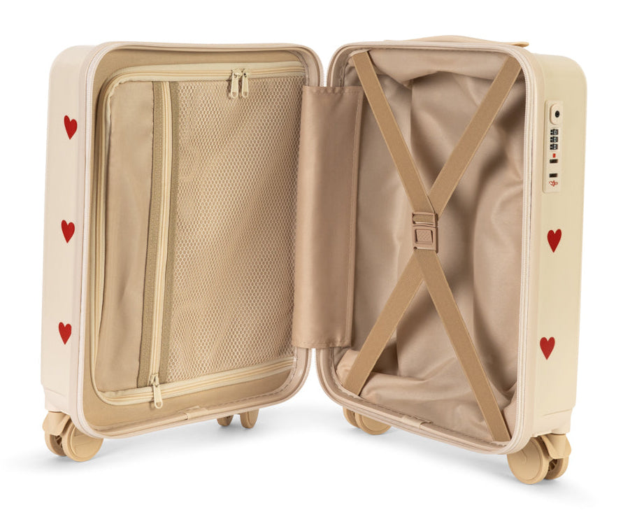 Open beige Konges Slojd Kids’ Travel Suitcase with red heart patterns, featuring an internal zippered mesh compartment, elastic garment straps, and a TSA lock.