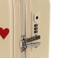 Cream-colored Kids’ Travel Suitcase by Konges Slojd featuring red heart patterns and a three-digit TSA lock.
