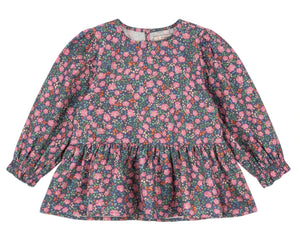 The Girls' Cianna Blouse by Konges Slojd is a long-sleeve woven cotton top for children, featuring a ruffled hem and a dark background with an all-over pink and purple floral print.