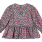 The Girls' Cianna Blouse by Konges Slojd is a long-sleeved, floral-patterned cotton top for children featuring a gathered waist and back button closure.