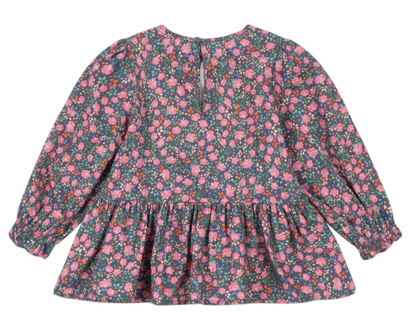 The Girls' Cianna Blouse by Konges Slojd is a long-sleeved, floral-patterned cotton top for children featuring a gathered waist and back button closure.
