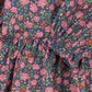Close-up of the Girls' Cianna Blouse by Konges Slojd, featuring woven cotton with a multicolored floral print and gathered elastic details for a stylish crinkle effect.